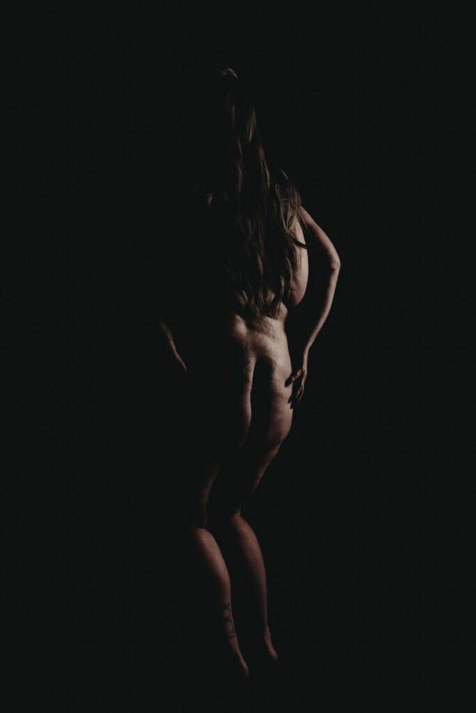 Plus size brunette woman's silhouette of her touching her butt. Featured in the blog post "Boudoir Inspo: Nudescape or Bodyscape Photography" nudescape, beautiful boudoir, boudoir style, imagery style, Colorado boudoir photographer, Body positive boudoir, Body Image, inspiration, style, black and white imagery, composition. Picture by Embodied Art Boudoir.