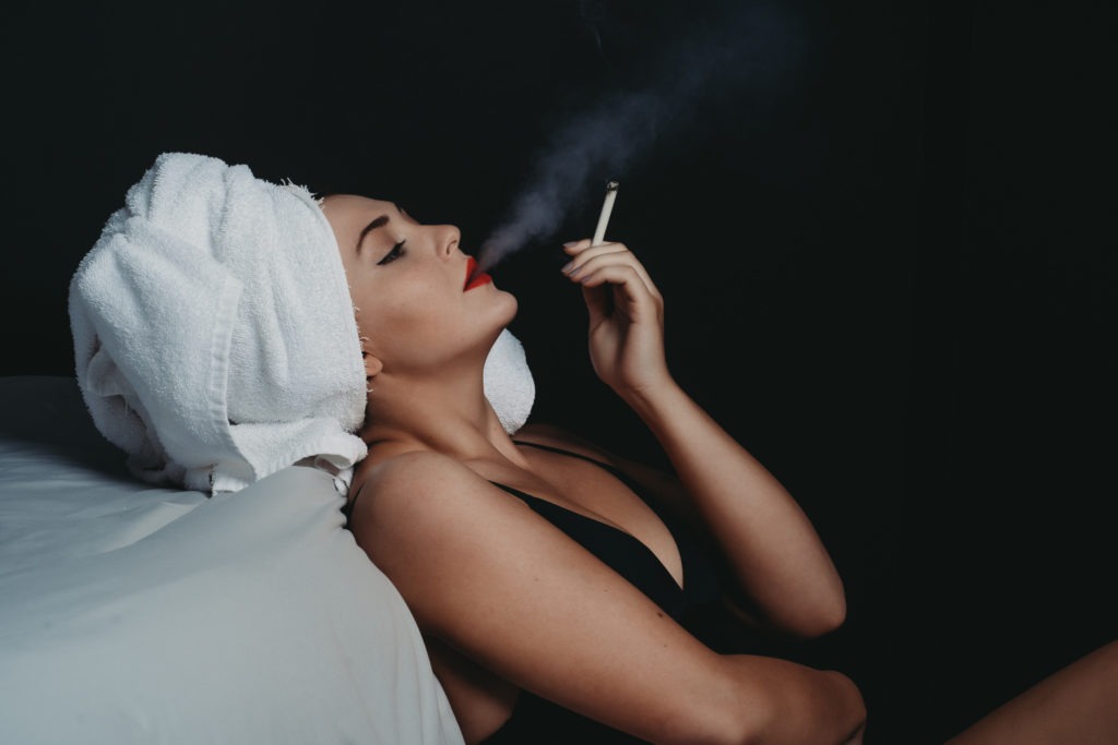 Women smoking cigarette wearing red lipstick and black lingerie with towel wrapping her hair, Photo by Embodied Art Boudoir. Boudoir photography, colorado boudoir, denver boudoir, boudoir makeup, photoshoot makeup, boudoir ideas, boudoir inspiration, plus size lingerie, lingerie, photoshoot outfits, flattering outfits, curvy lingerie, lingerie look, lingerielook photoshoot, makeup looks, bold lip, smoky eye, winged eyeliner, pop of color makeup, natural makeup, no makeup