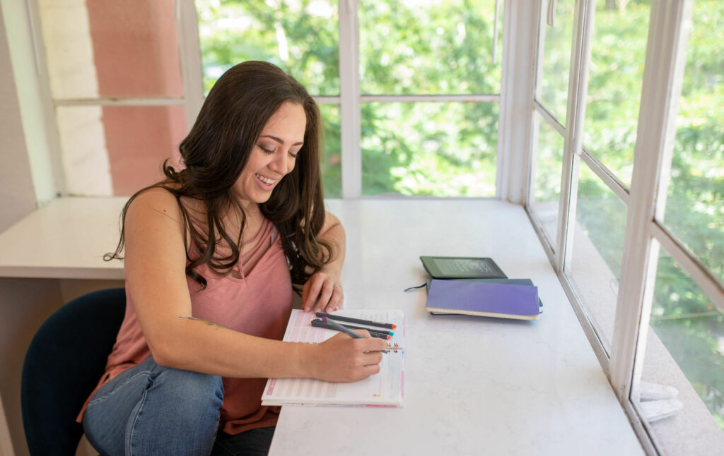 A woman sitting at a sunny window and journaling! Photo by Embodied Art Boudoir. Journaling, journal prompts, journal ideas, journal inspo, body image, body love, body appreciation, body positive, fat positive, boudoir, boudoir photos, boudoir session, boudoir photography, denver boudoir, colorado boudoir, boudoir inspo, boudoir ideas