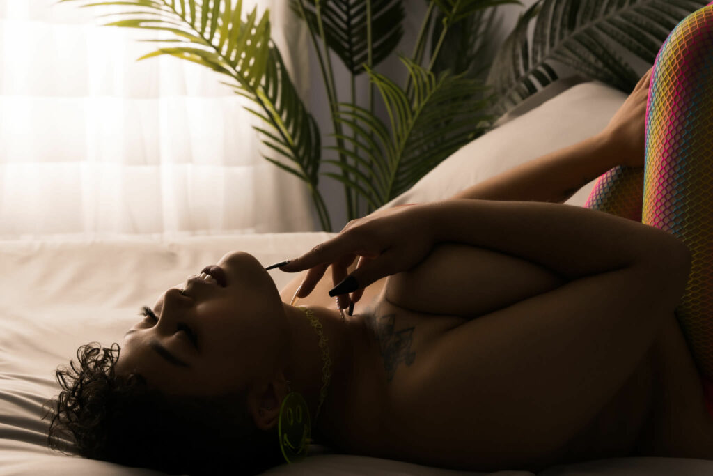 Woman lying on bed sensually, touching face with her eyes closed, wearing only colourful leggings. Photo by Embodied Art. Boudoir photography, self-care, journal, journal inspiration, journaling, journal addict, journal lover, journal inspo, self-care tips, self-care first, self-care routine, self-care tips, self-care daily, healthy choices, healthy habits, habits, success habits, habits for success, me time, quotes to live by, colorado, colorado photographer, Denver boudoir, Denver boudior, Colorado boudior, Embodied art boudoir, boudior, boudoir, boudoir photo, photographer