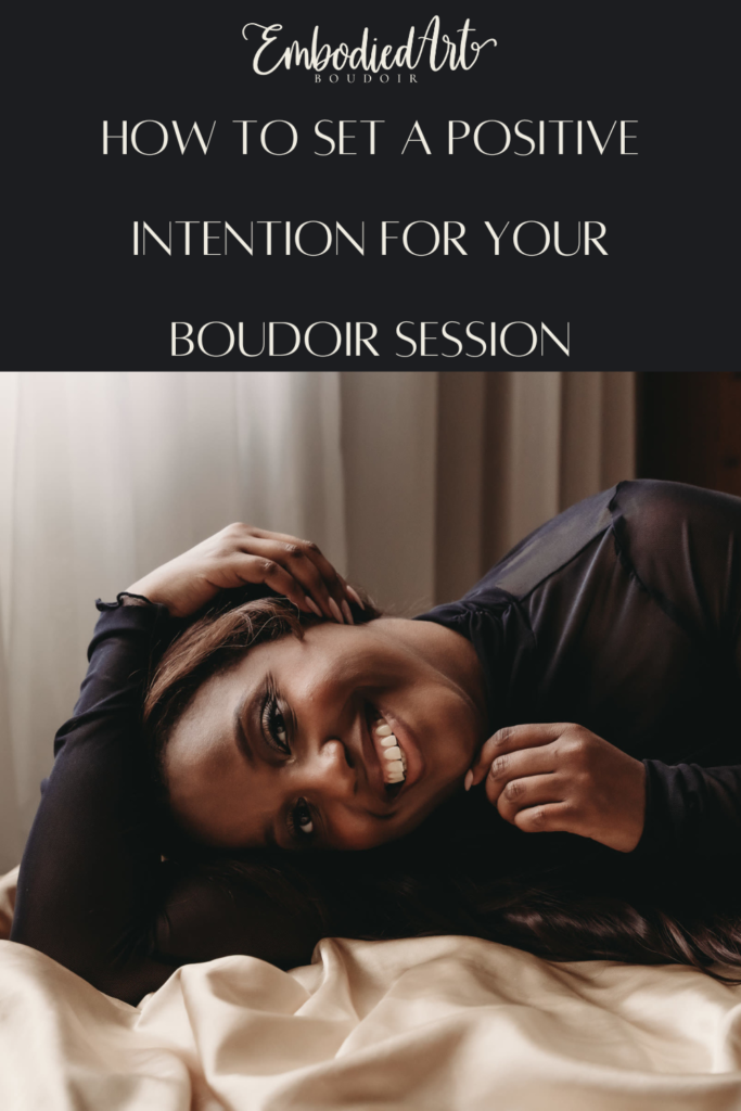 Woman smiling, looking directly at camera happily touching side of face wearing a sheer black shirt. Photo by Embodied Art Boudoir. Intentions, intention setting, goal setting, boudoir photoshoot, boudior, buodoir, Denver boudoir, Colorado boudoir, boudoir photographer, self love, growth journey, affirmations, positive intentions, positive affirmations, self love journey, boudoir photography, Denver portrait photography, Denver portrait photographer, Boulder boudoir, fort collins boudoir, colorado springs boudoir, how to set an intention