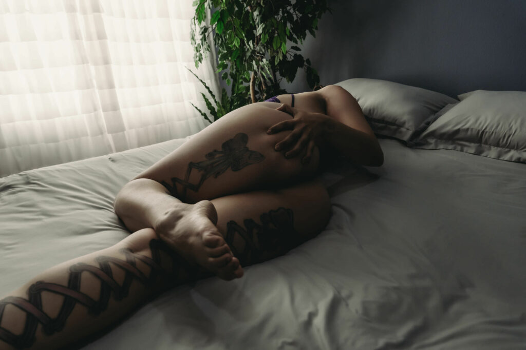 Woman lying on bed, showing the tattoos on the back of her legs. Photo by Embodied Art Boudoir. Affirmations, Affirmation Cards, mindfulness, confidence, self love, self love journey, affirmation practice, daily routine, self care routine, self care, female empowerment, self confidence, self worth, the body deck, connection, shop online, cards, body positivity, boudoir photoshoot, colorado boudoir, denver boudoir, boulder boudoir, colorado springs boudoir, boudoir inspiration, photography inspiration