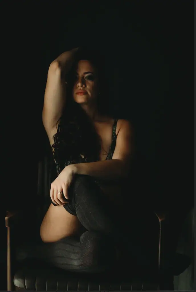 Brunette Woman with wavy hair sitting on a chair cross-legged wearing thigh high socks and a bra.. Featured in the blog "Cozy Boudoir Photography" cozy, cozy boudoir, cozy vibes, cozy outfits, cozy and comfortable, cozy boudoir photography, cozy inspiration, keep it cozy, boudoir outfit, boudoir outfit inspiration, what to wear to boudoir, colorado boudoir, denver boudoir, boulder boudoir, colorado springs boudoir, boudoir ideas, boudoir poses, boudoir inspiration, photography inspiration. Photo by Embodied Art Boudoir.