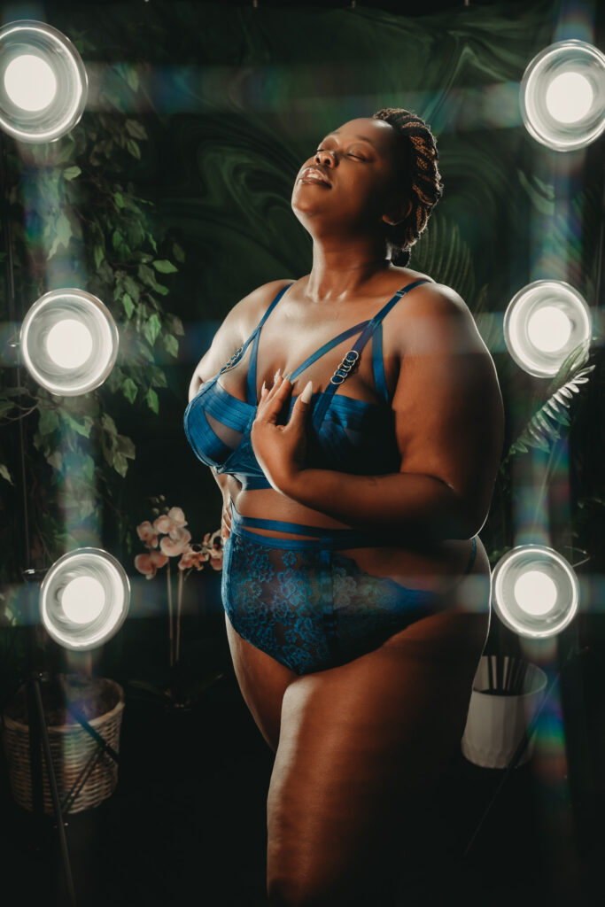 Woman standing in front of photos wearing a dark blue matching lingerie set. Photo by Embodied Art Boudoir. Find Your photographer, boudoir photographer, boudoir photographers, right photographer, choose the right boudoir photographer, female boudoir photographer, boudoir images, classic boudoir, boudoir style, classy boudoir, sensual photography, sensual boudoir, colorado boudoir, denver boudoir, boulder boudoir, colorado springs boudoir, boudoir ideas, the perfect match.