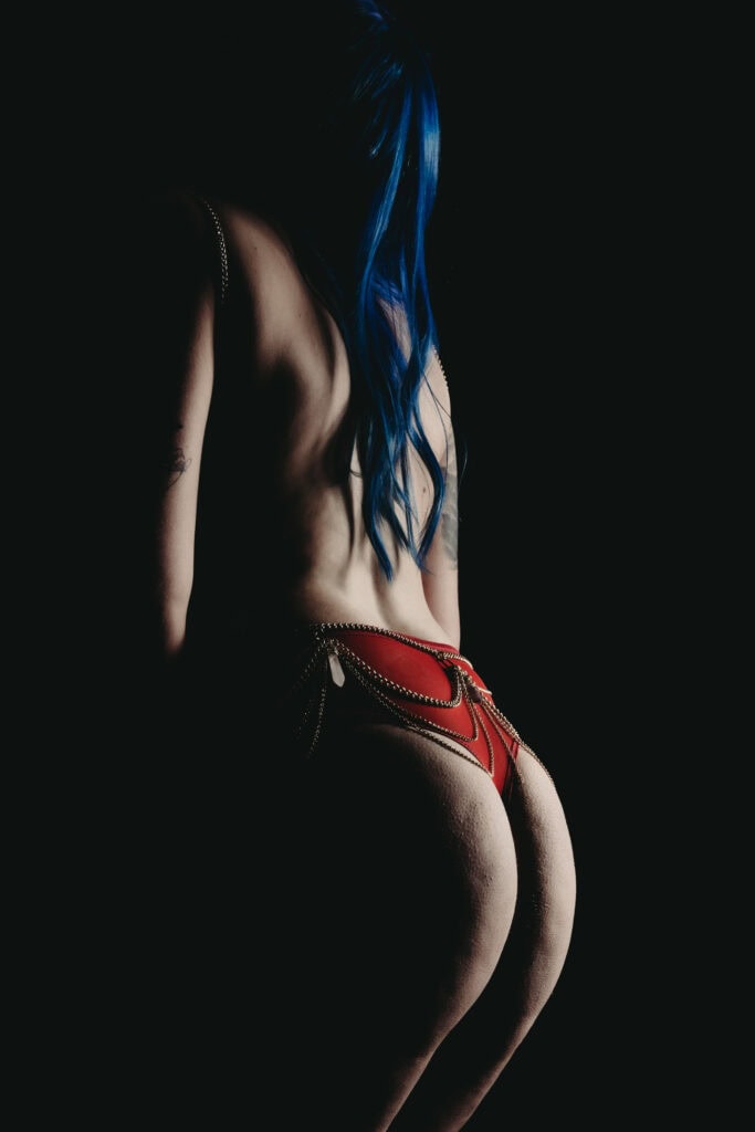 Woman wearing body chains and red panties and nothing else. Photo by Embodied Art Boudoir. Embrace sensuality, sensual, wellness, connection, embodied, desires, five senses, connected, imperfectly perfect, body journey, body love, colorado boudoir, denver boudoir, boulder boudoir, colorado springs boudoir, boudoir ideas, boudoir poses, boudoir inspiration, photography inspiration