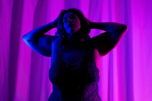 Boudoir portrait of a woman with purple lighting in Denver, Colorado.